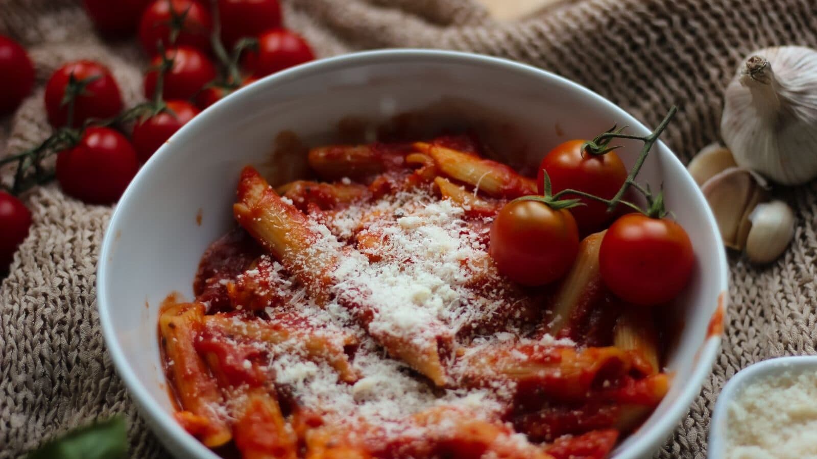 Penne pasta in tomato sauce with parmesan and cherry tomatoes