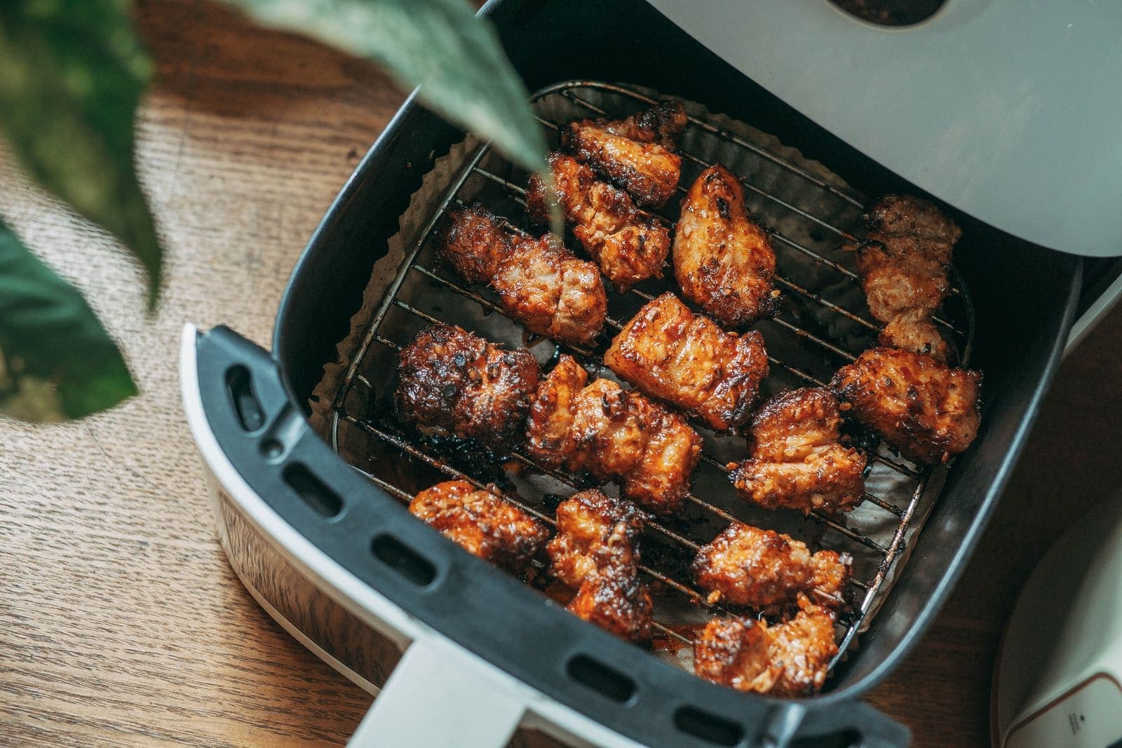 Crispy chicken pieces cooking in a modern air fryer basket