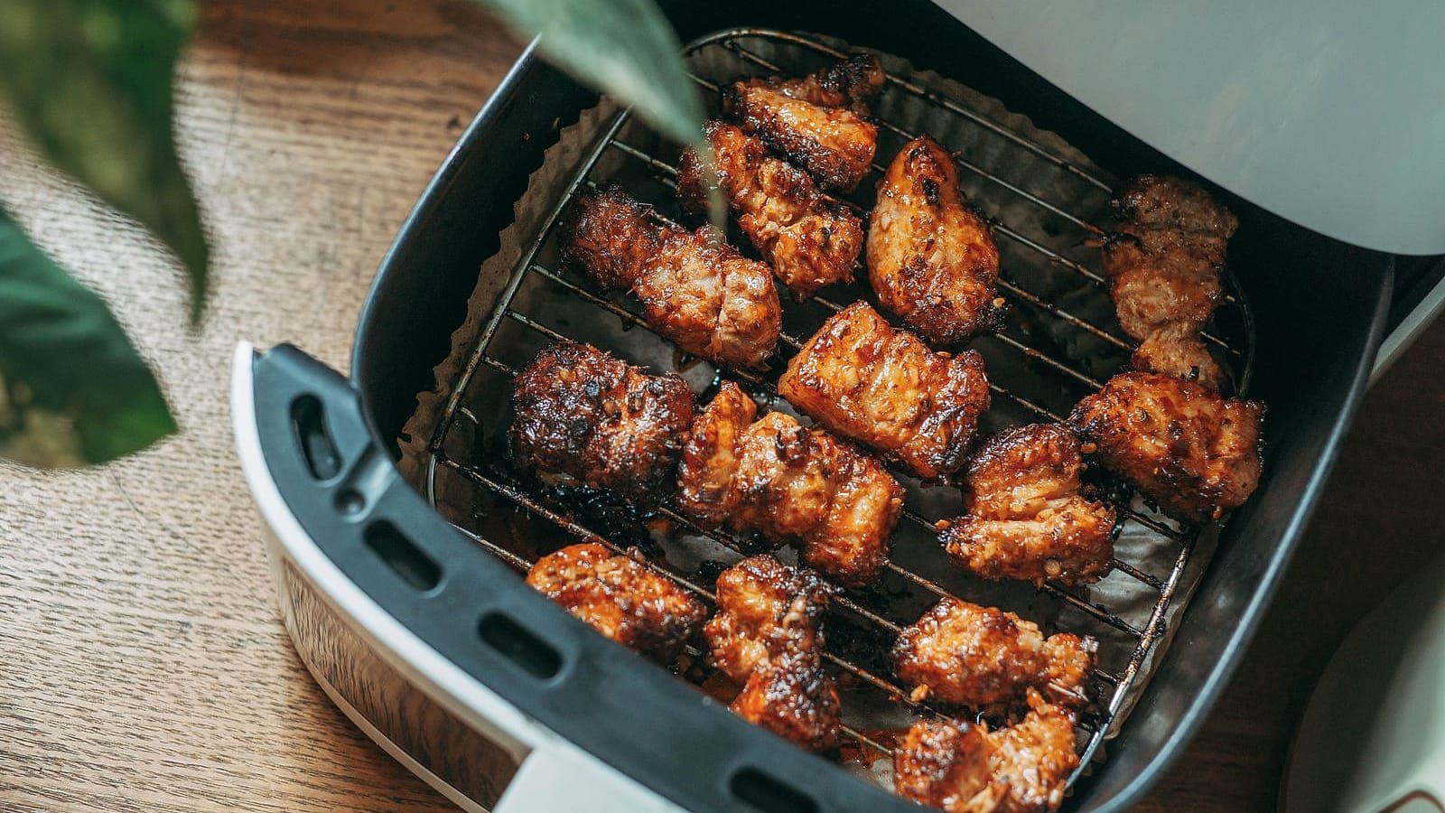 Seasoned chicken wings crisping in an air fryer basket