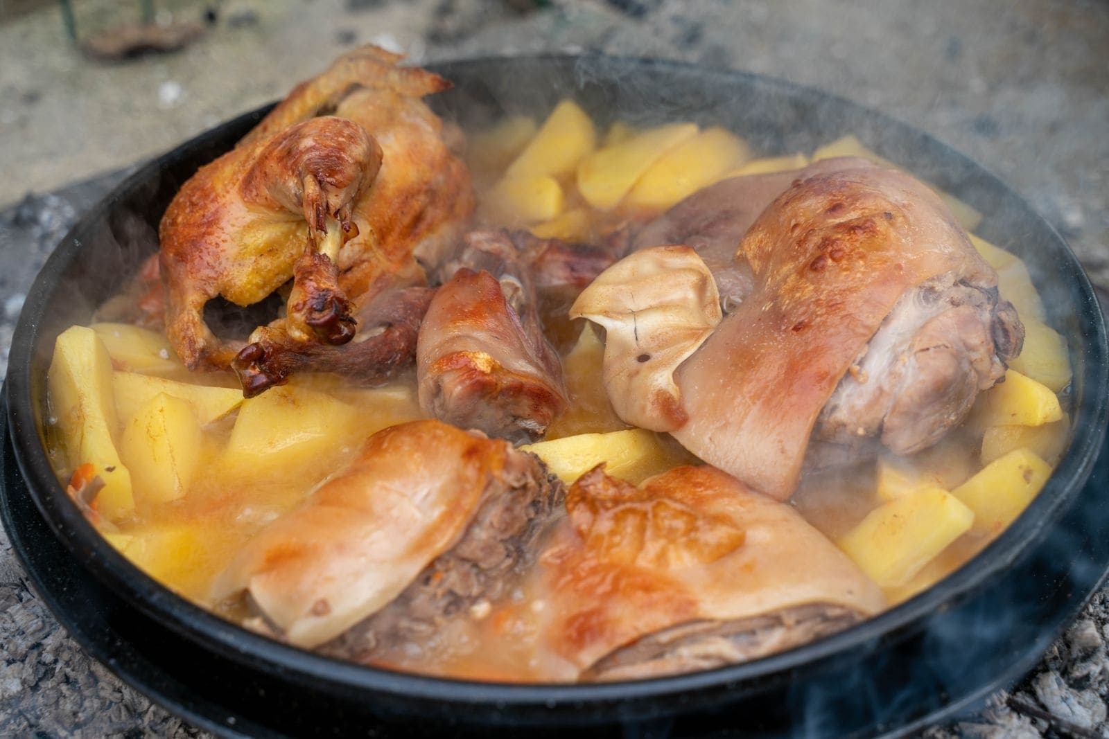 Braised chicken and potatoes in a rustic Dutch oven