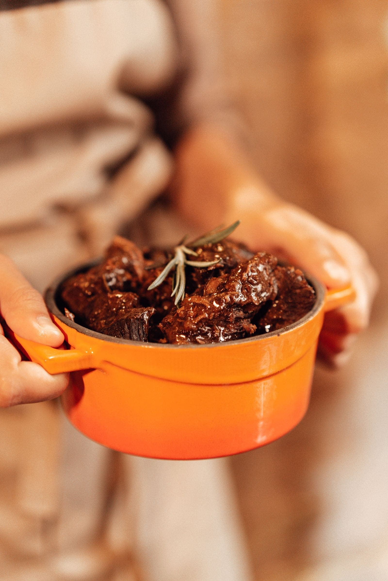 Braised short ribs with rosemary in an orange enameled Dutch oven
