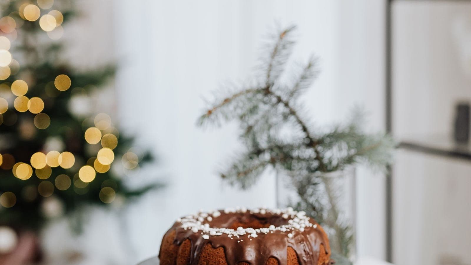 An elegant holiday table setting with gold flatware, white plates, and a wrapped gift